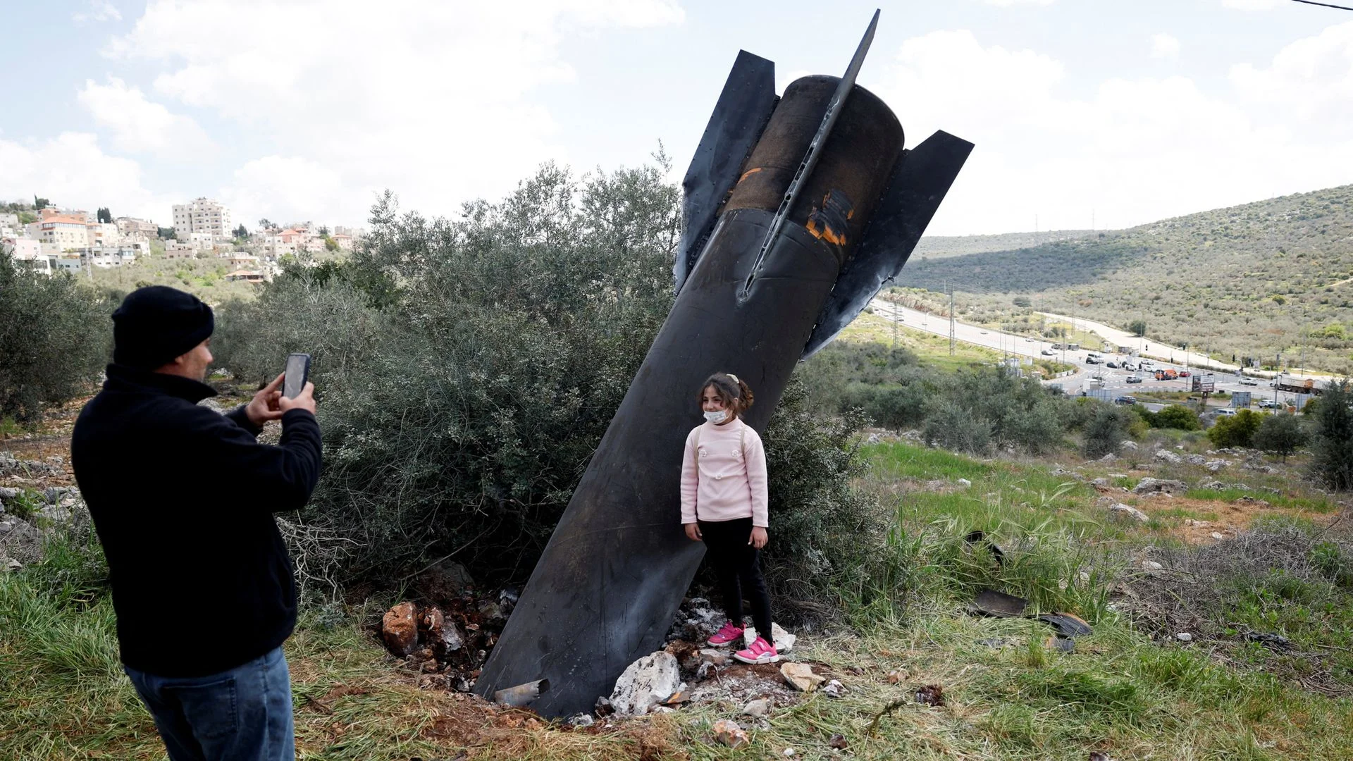 Children play around missiles as remnants of projectiles pictured across Middle East